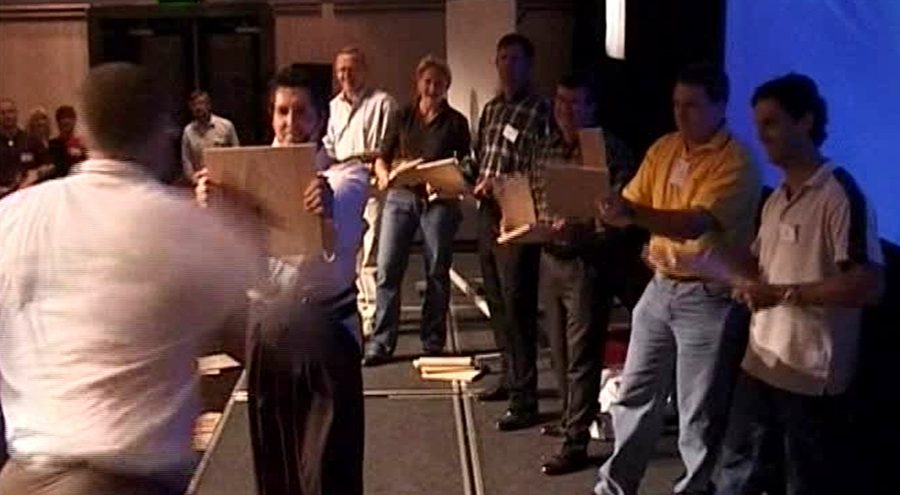 Participants holding boards for Mark's board-breaking exercise