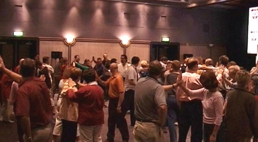 A conference audience on their feet during one of Mark's sessions